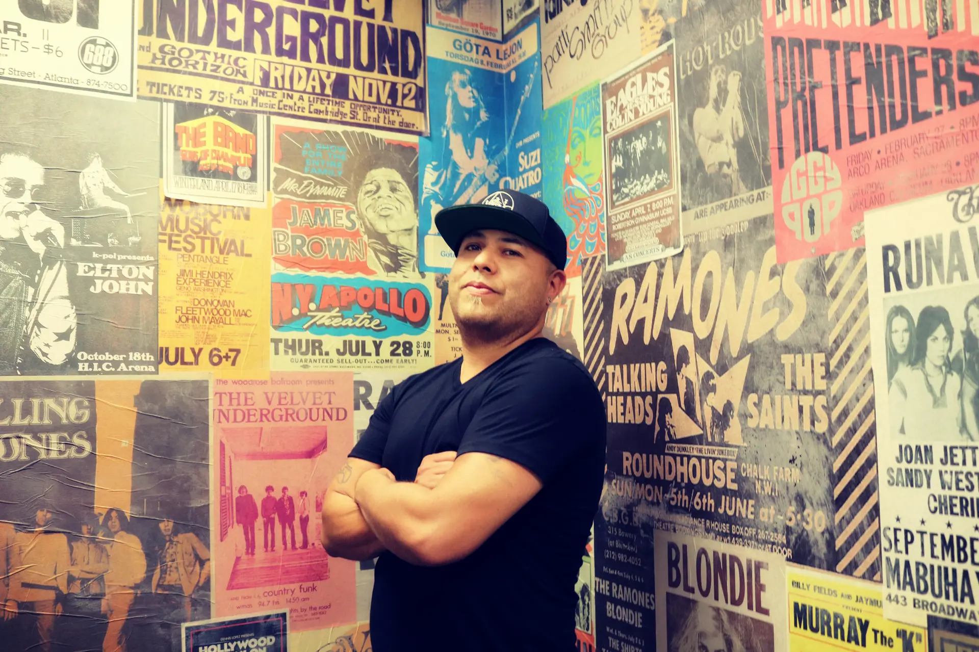 John J in front of a wall of vintage concert posters